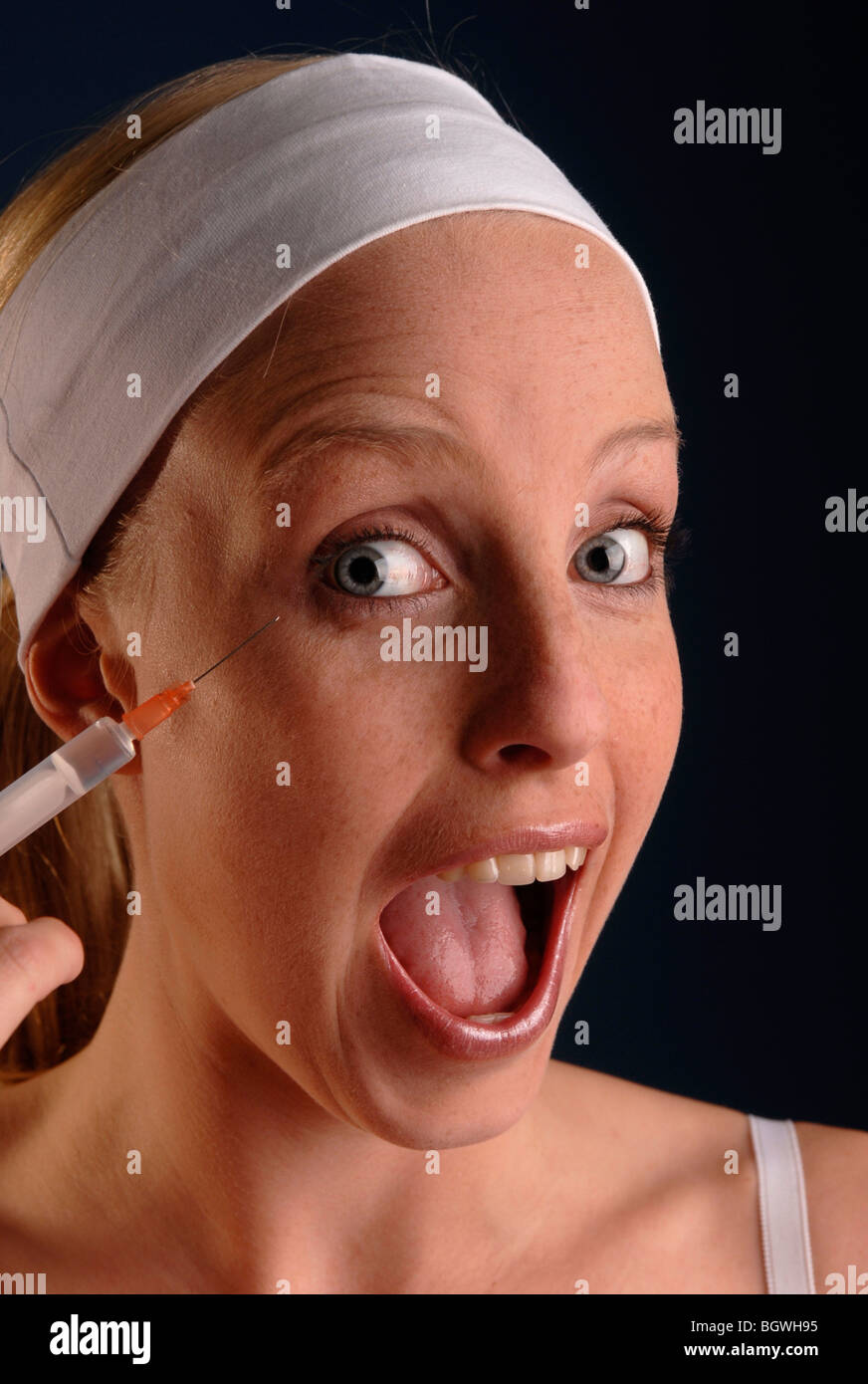 Young woman holding a syringe in her hand Stock Photo