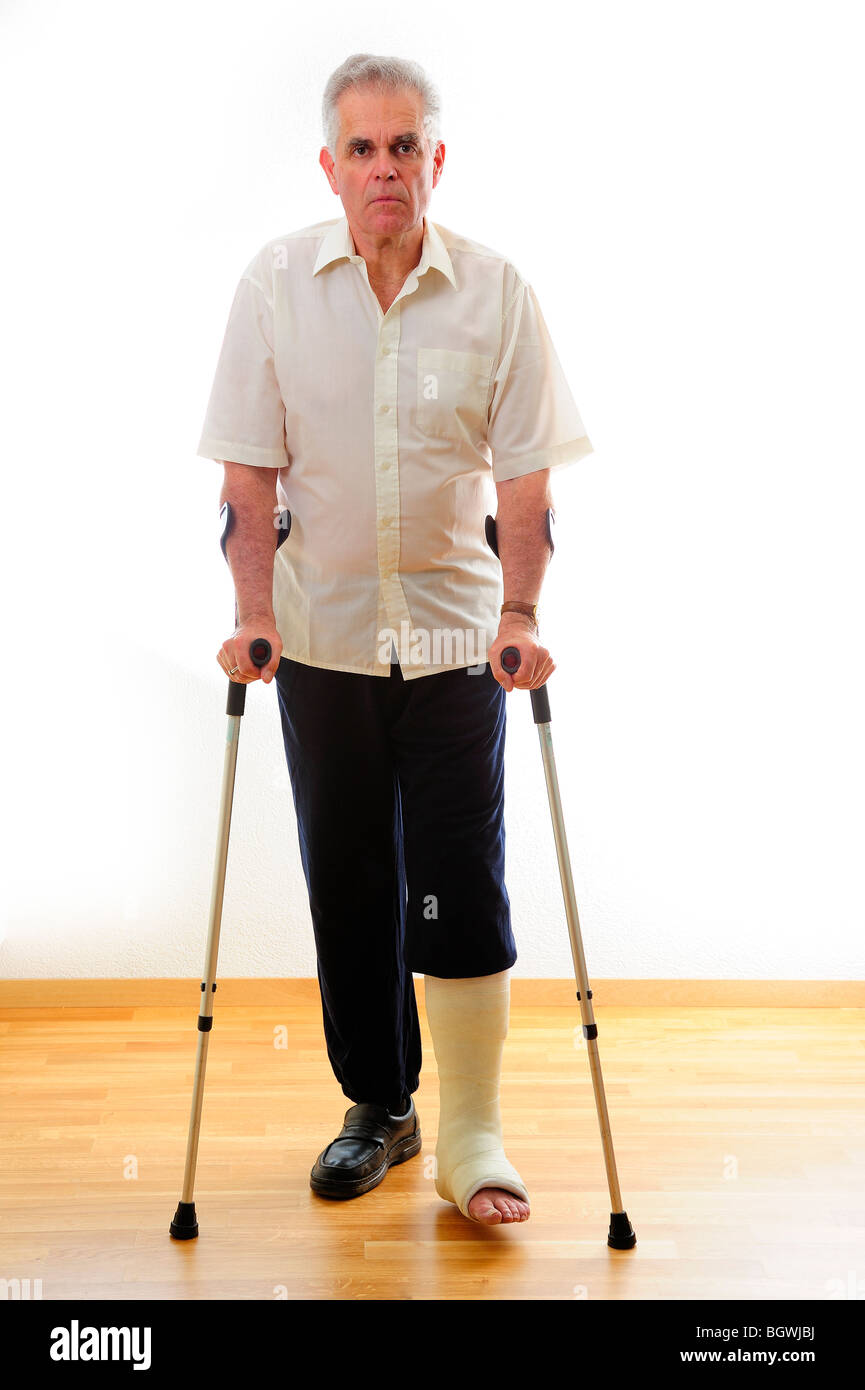 A man with a broken leg, on crutches, against a white background Stock Photo Alamy
