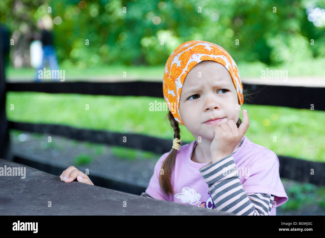 Girl sitting at picnic table Stock Photo Alamy