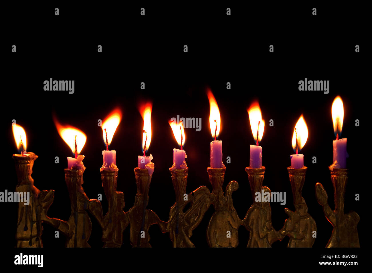 burning hanukkah candles in a menorah on black background Stock Photo
