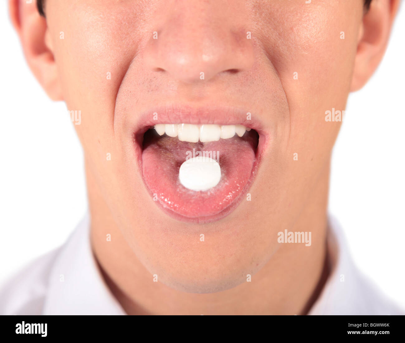 A young man taking a pill. All isolated on white background Stock Photo