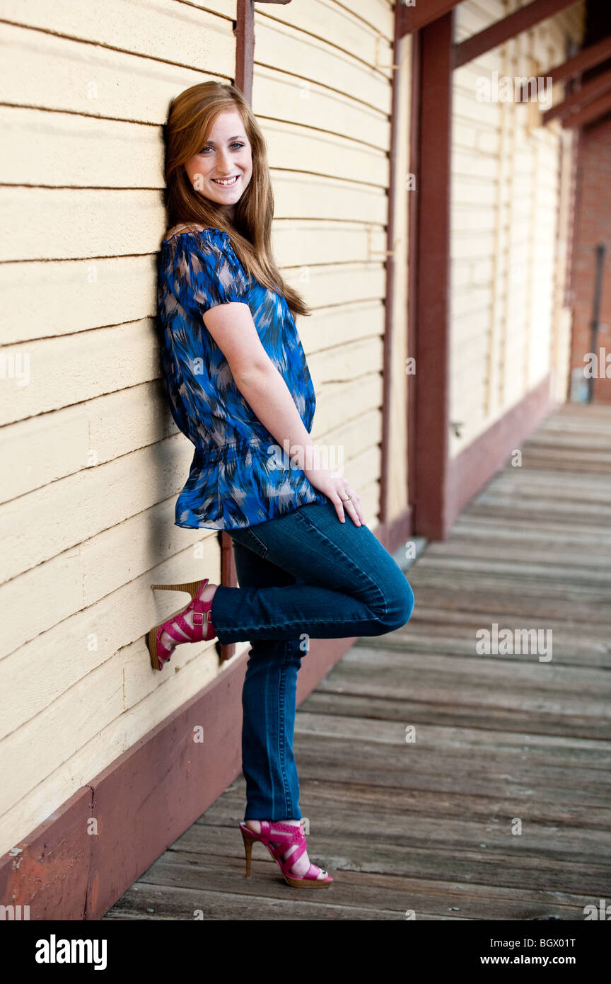 Pretty redheaded teen girl leaning against a wall Stock Photo