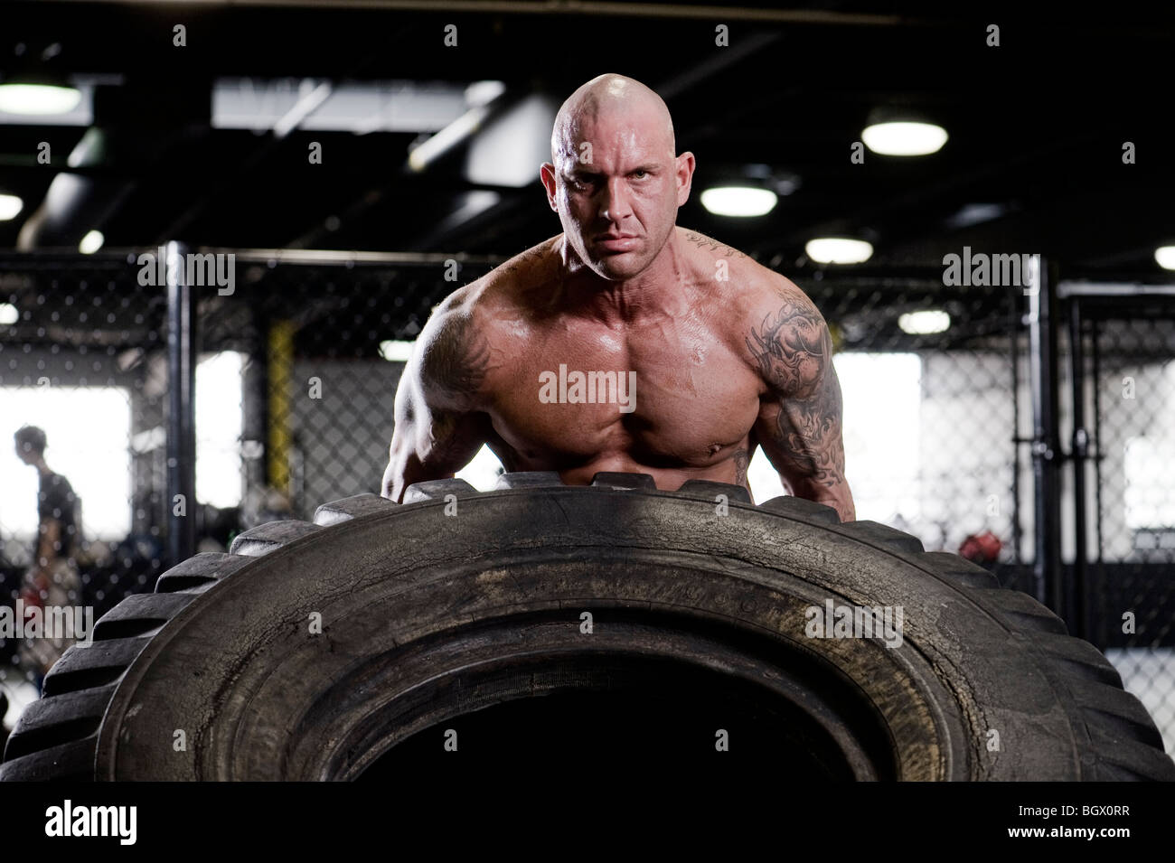 Strong man lifting a tire. Stock Photo