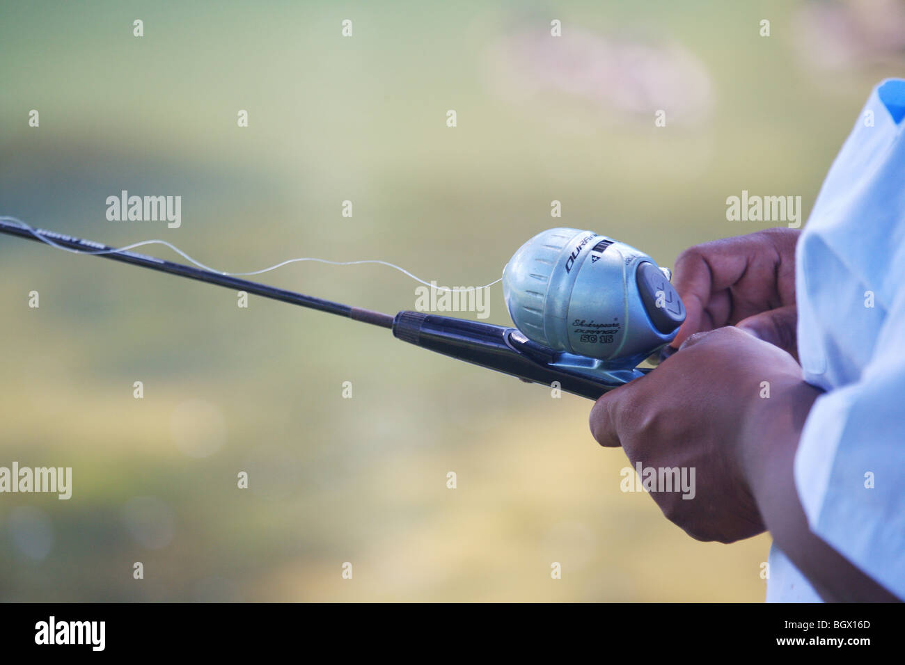 AFRICAN-AMERICAN HANDS HOLDING A SHAKESPEARE DURANGO SC15 ROD AND REEL  BLACK MAN ETHNIC GROUP MINORITY Stock Photo - Alamy