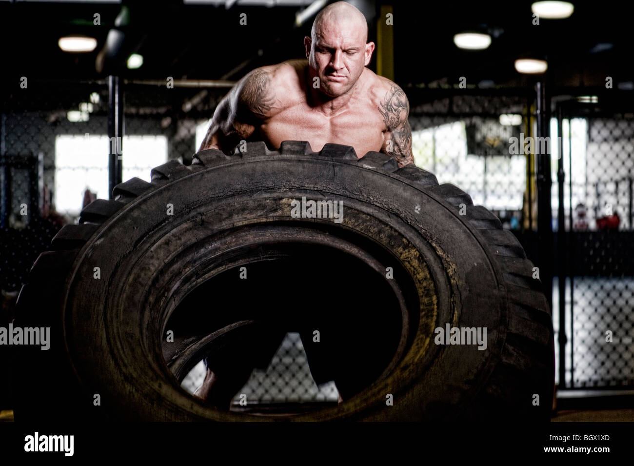 Strong man lifting a tire. Stock Photo