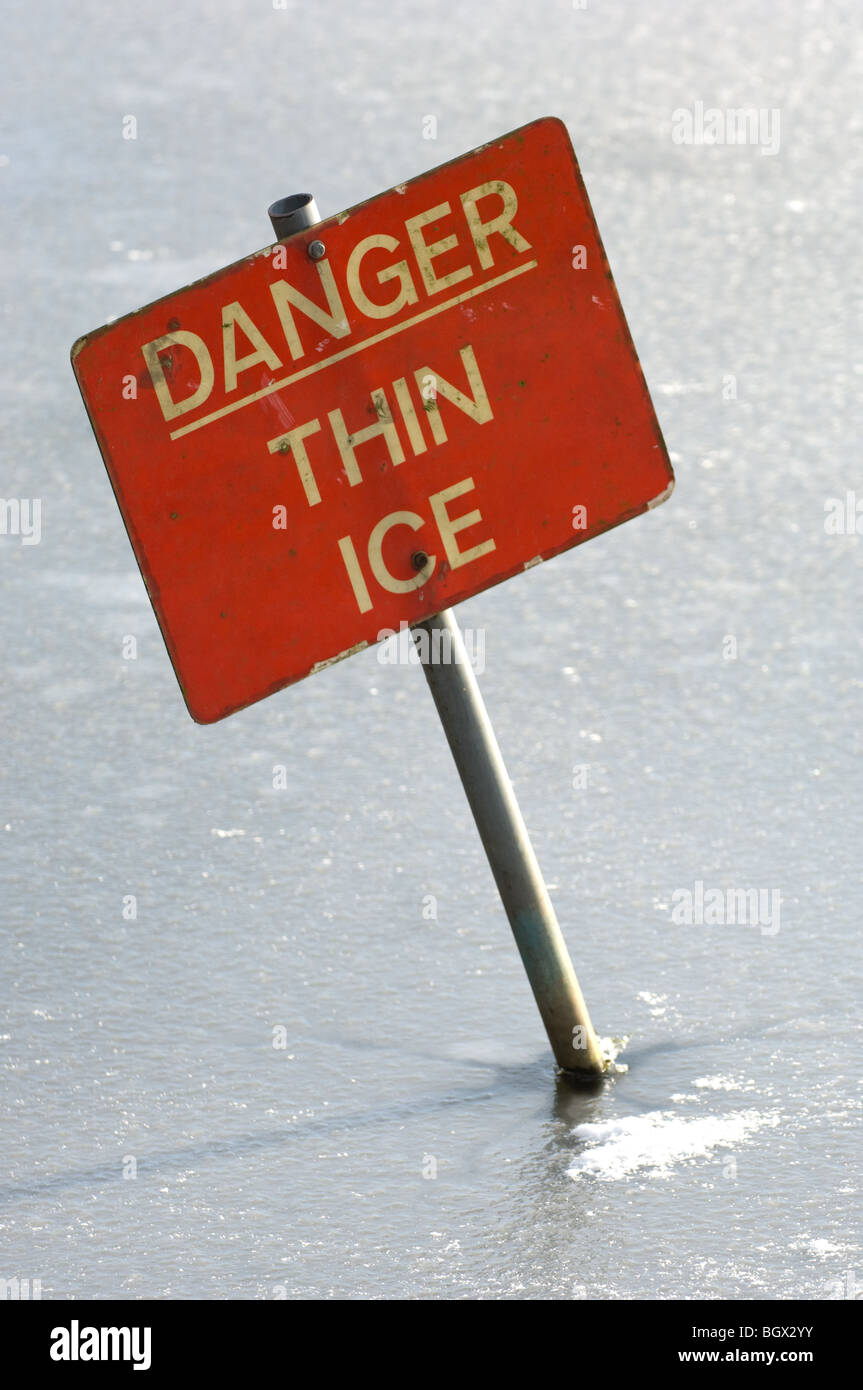 Warning sign informing not to walk onto the lake due to thin ice. Stock Photo