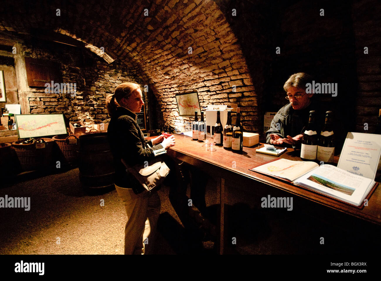 Woman buying wine in the cave of Dufouleur Pere et Fils Nuits-St-Georges, Bourgogne (Burgundy). NB: this image includes image noise. Stock Photo