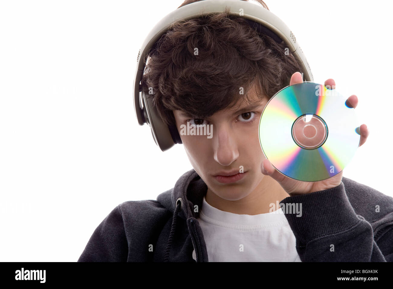 Portrait of young man listening to music displaying CD isolated on ...