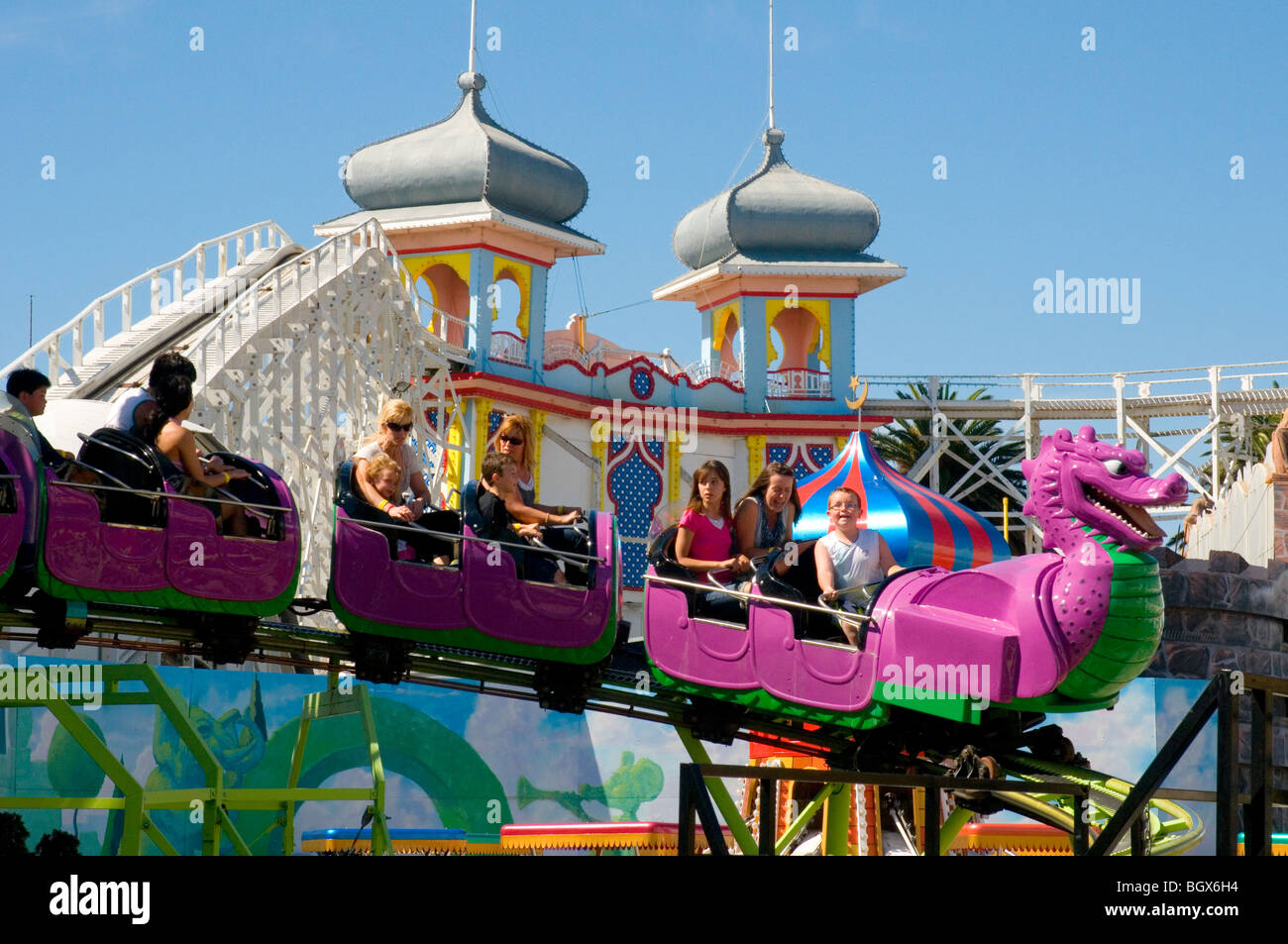 Riding the Silly Serpent at Luna Park, St Kilda, Melbourne, Australia. Behind is the century-old Scenic Railway rollercoaster Stock Photo