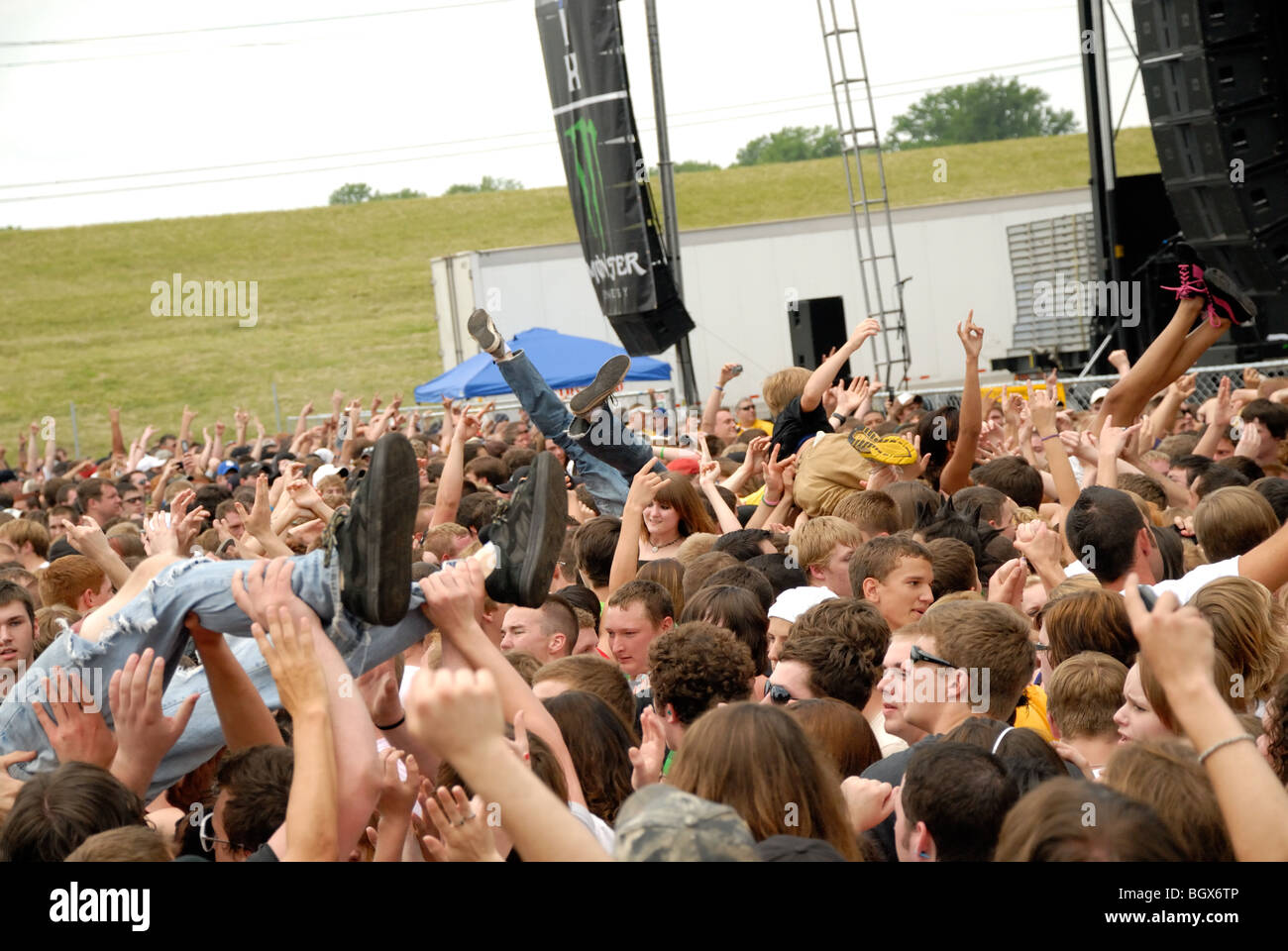 Crowd at an outdoor festival rock concert, where people are being crowd-surfed. Stock Photo