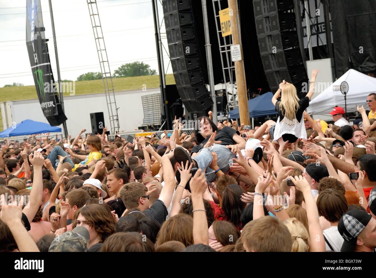 Crowd at an outdoor festival rock concert, where people are being crowd-surfed. Stock Photo