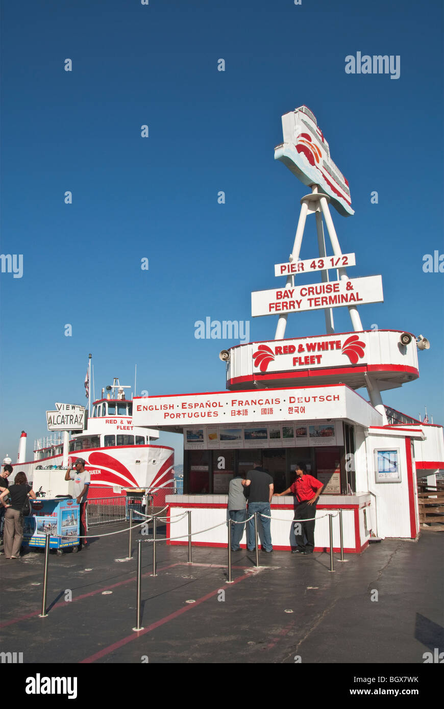 California San Francisco Fisherman's Wharf Red & White Fleet ferry and tour boats couple at left inquire about bicycle rental Stock Photo