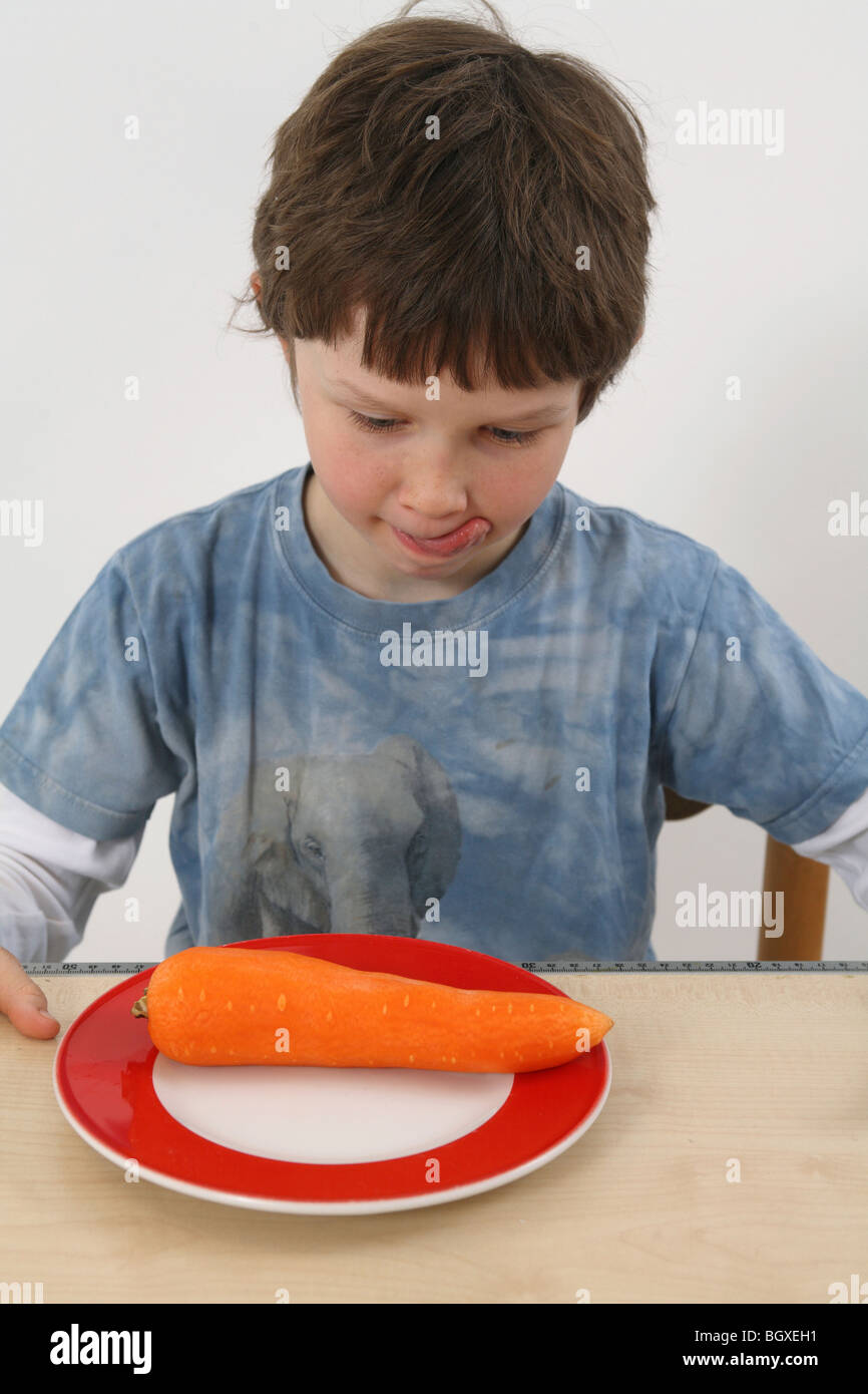 A boy at a plate with a carrot on it, Berlin, Germany Stock Photo