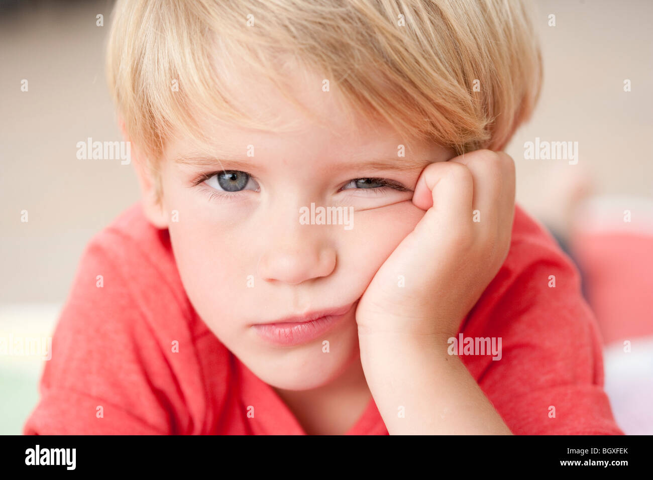 young boy looking bored at viewer Stock Photo