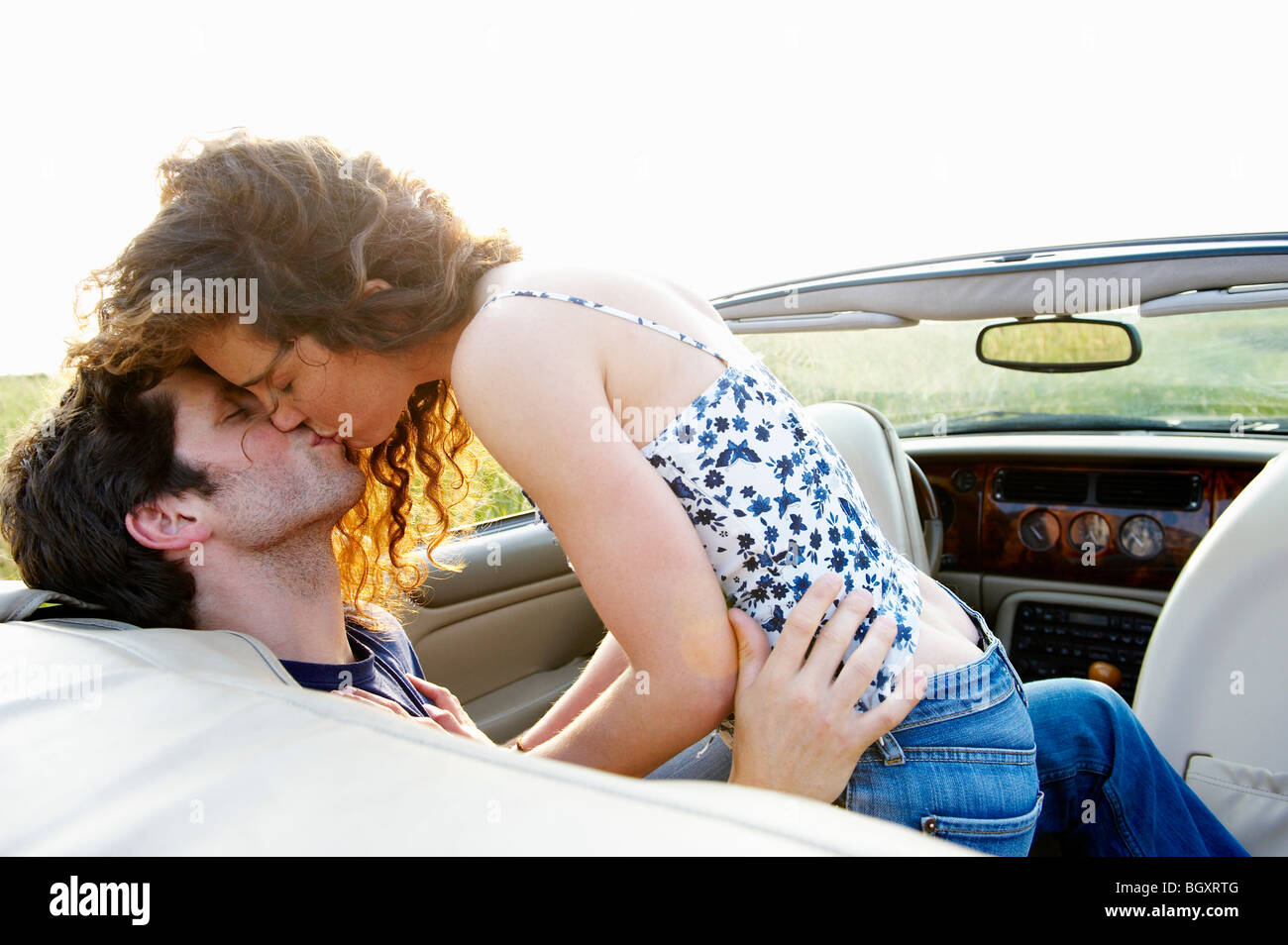 Couple kissing in a convertible Stock Photo