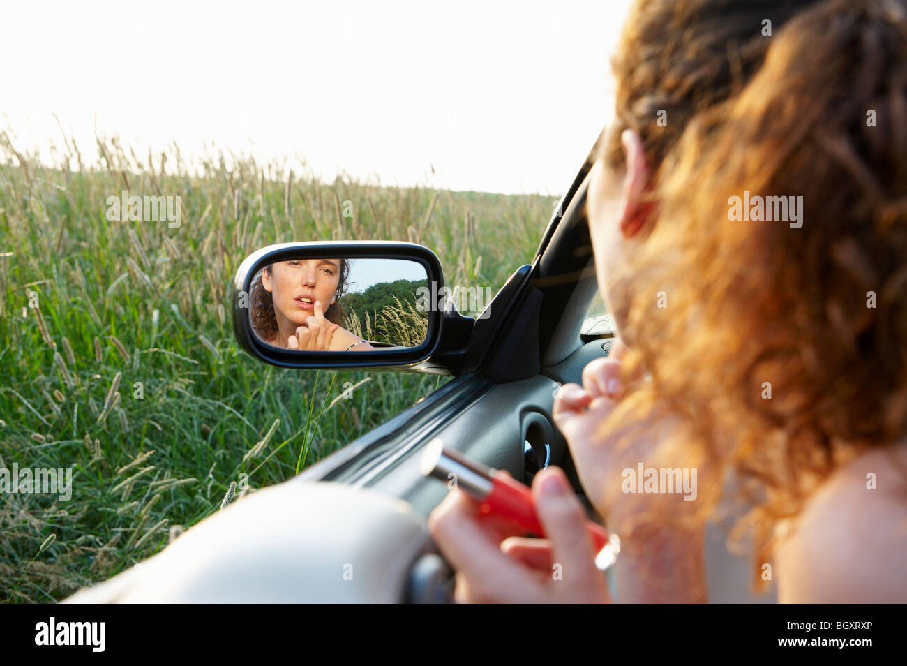 Reflection of woman in rearview mirror Stock Photo