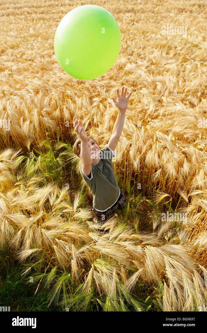 Boy playing with balloon in wheat field Stock Photo - Alamy