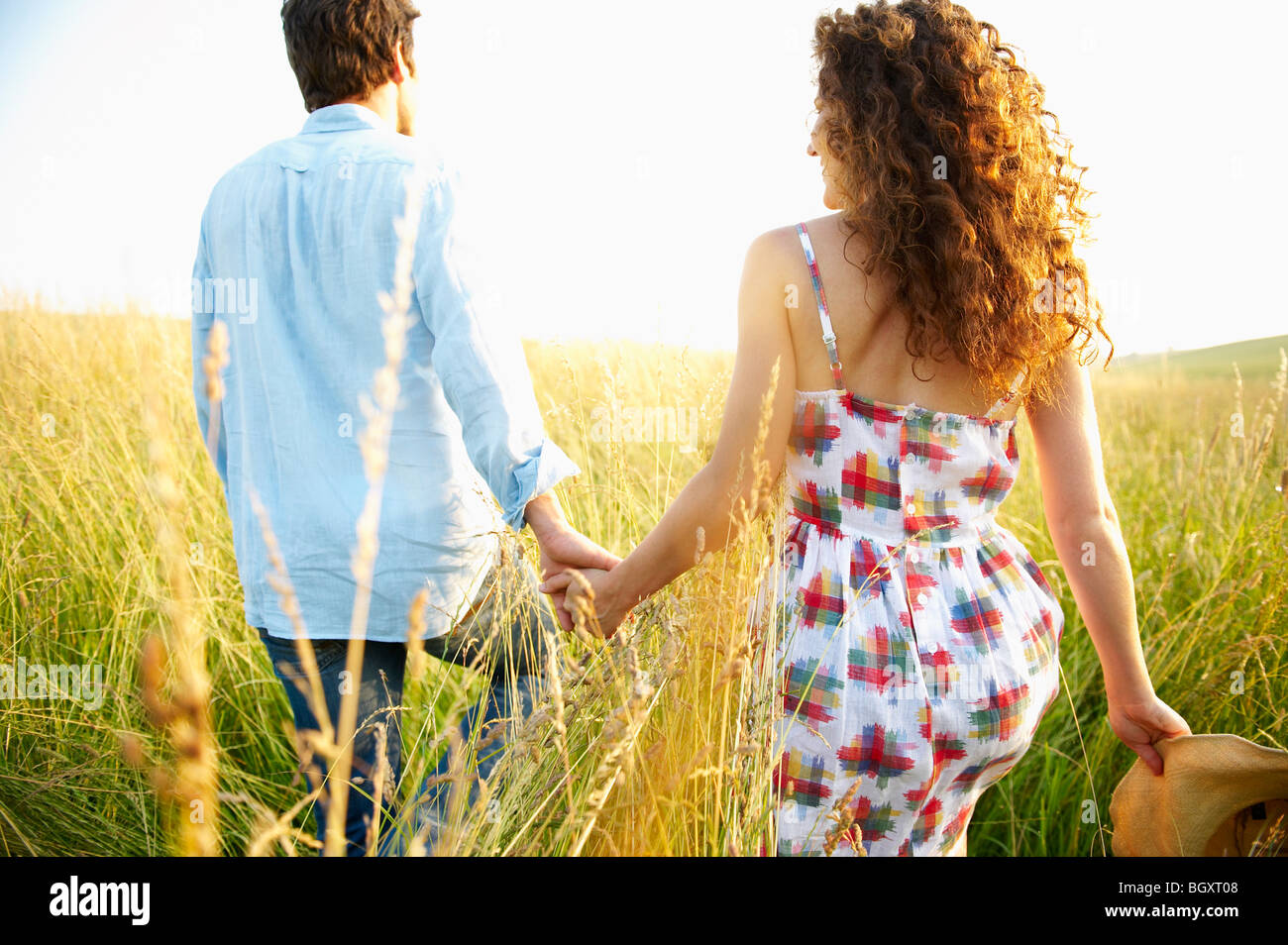 Couple holding hands in a wheat field Stock Photo - Alamy