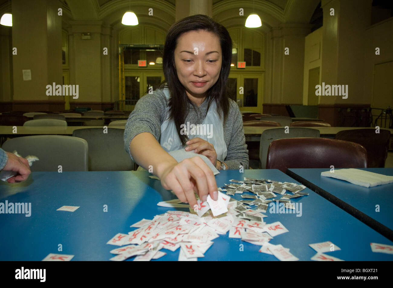 Volunteer sorts salt and pepper packets prior to Sunday lunch at the St