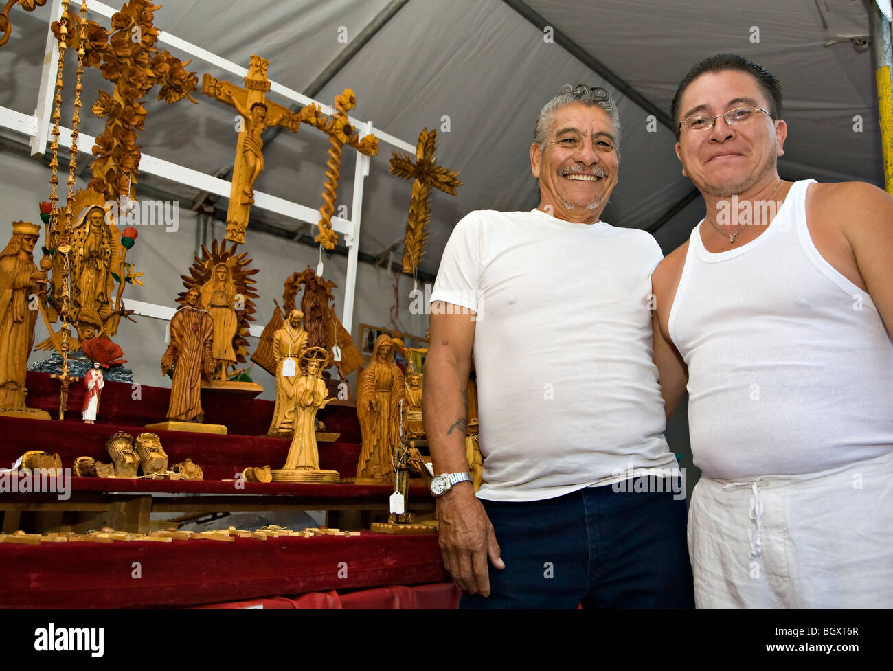 Joe and Joseph Morales pose in front of their wood carvings at the Santa Fe Indian Market Stock Photo