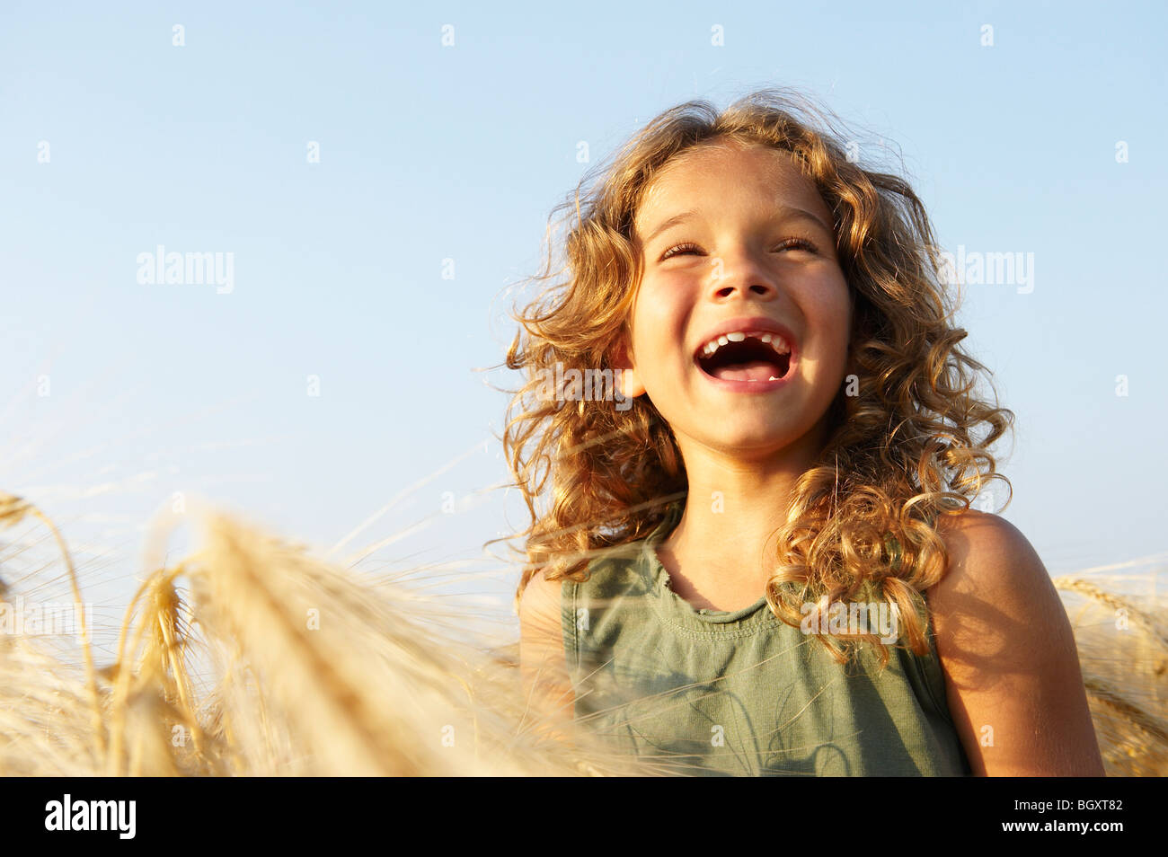 Girl smiling in a wheat field Stock Photo - Alamy