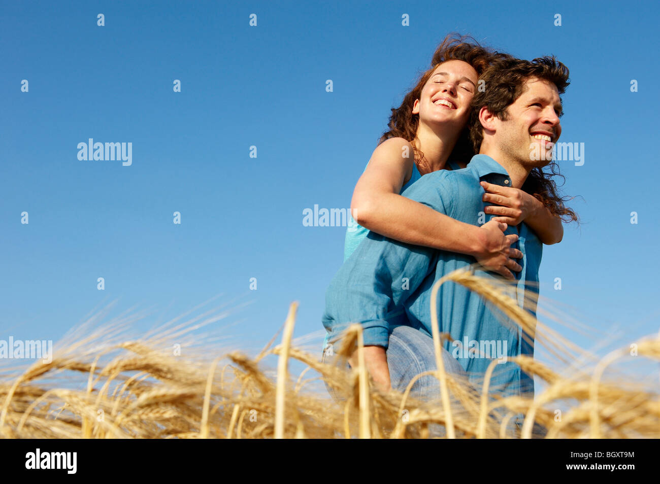 Man carrying woman in a wheat field Stock Photo