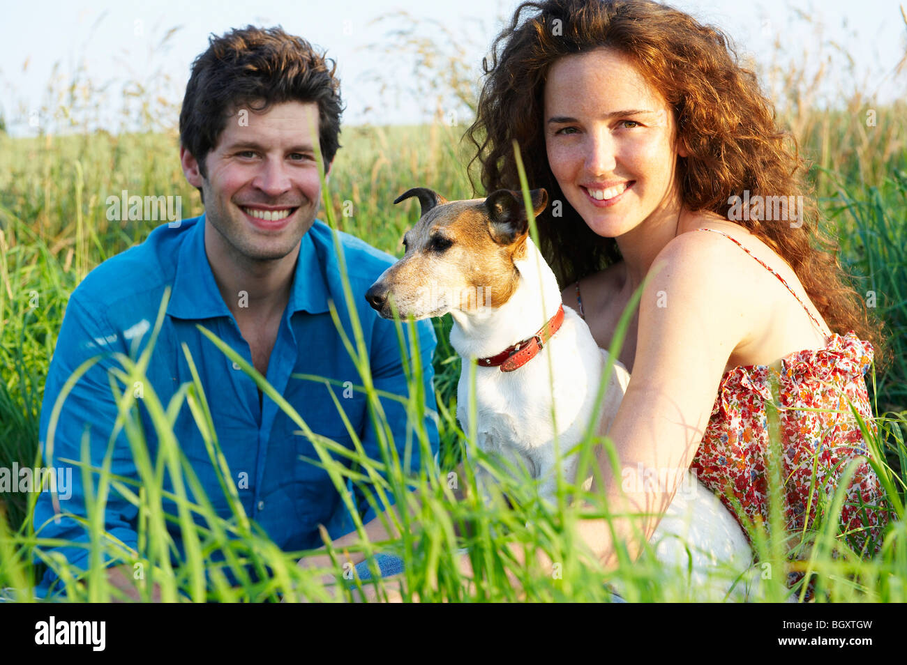 Couple with dog in a wheat field Stock Photo