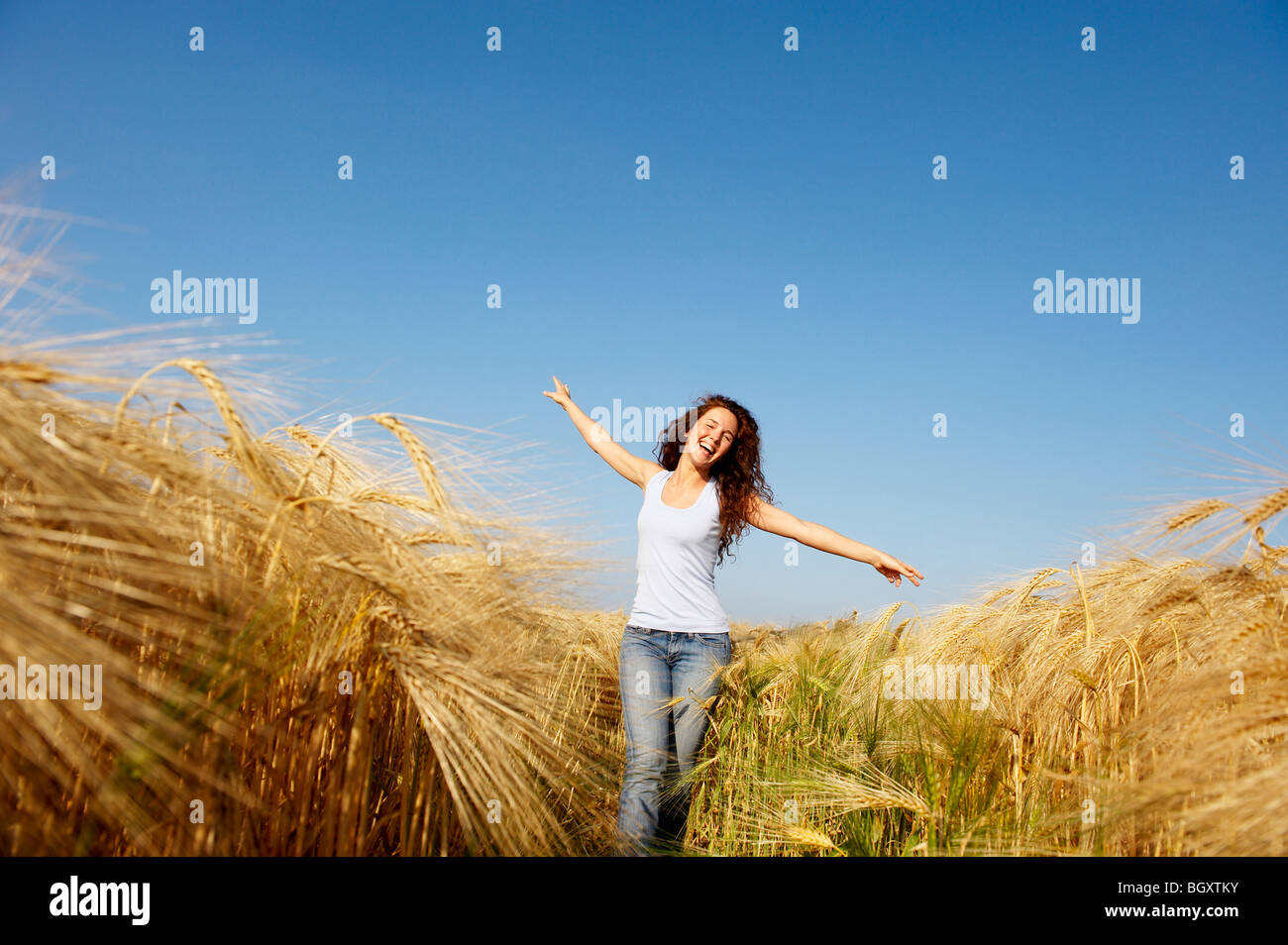 Woman walking in a wheat field Stock Photo - Alamy