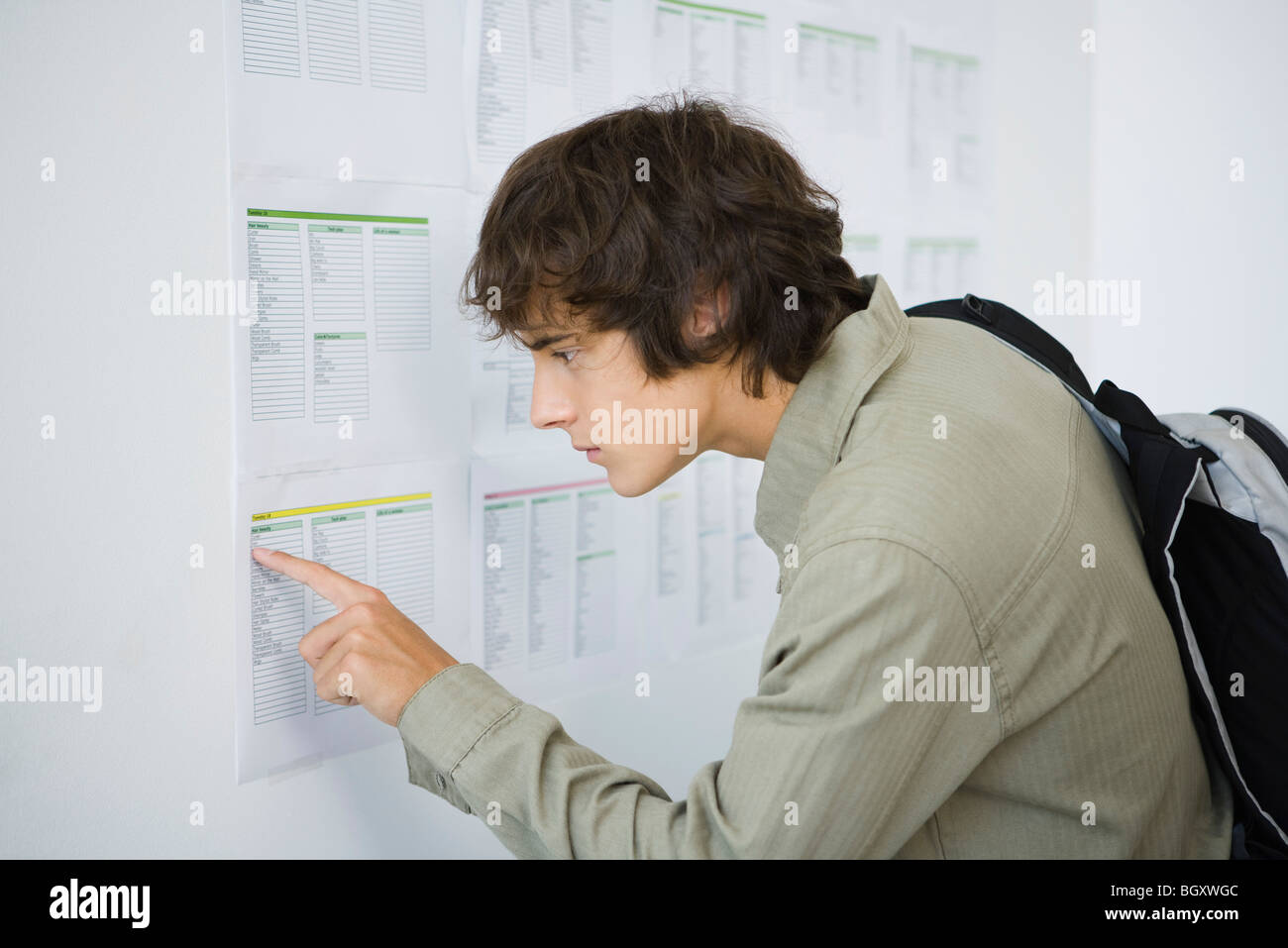 Male college student checking results posted on bulletin board Stock Photo