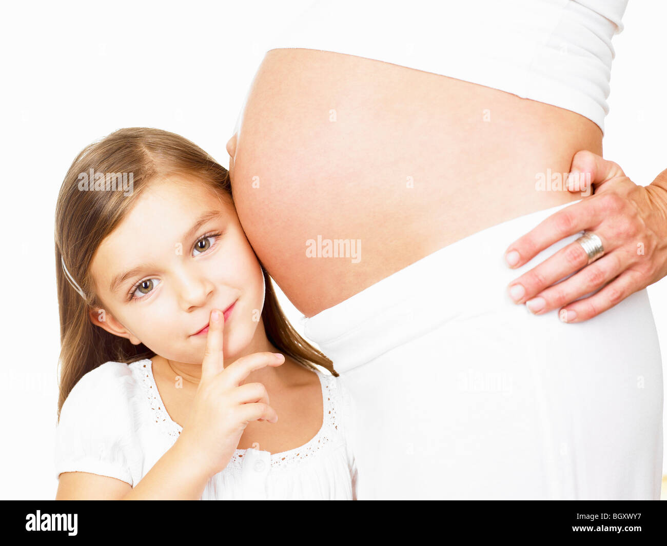 Girl next to her mother's pregnant belly Stock Photo