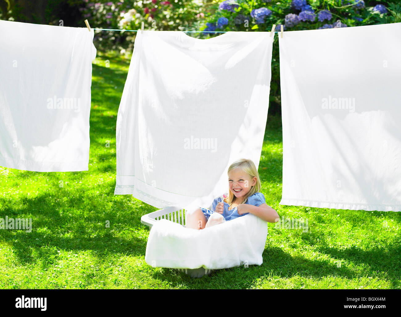 Girl playing in the laundry basket Stock Photo