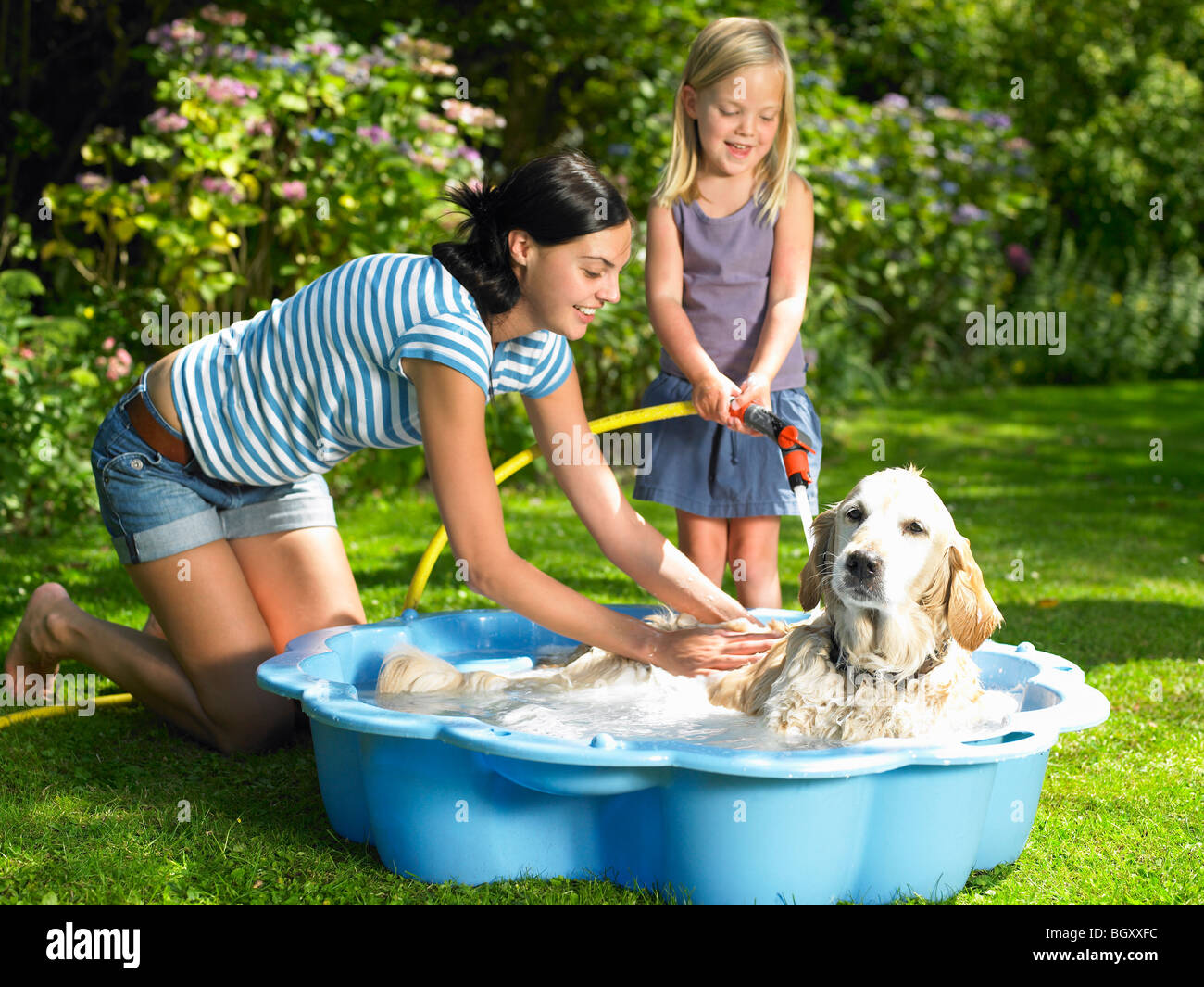 Mother and daughter washing the dog Stock Photo