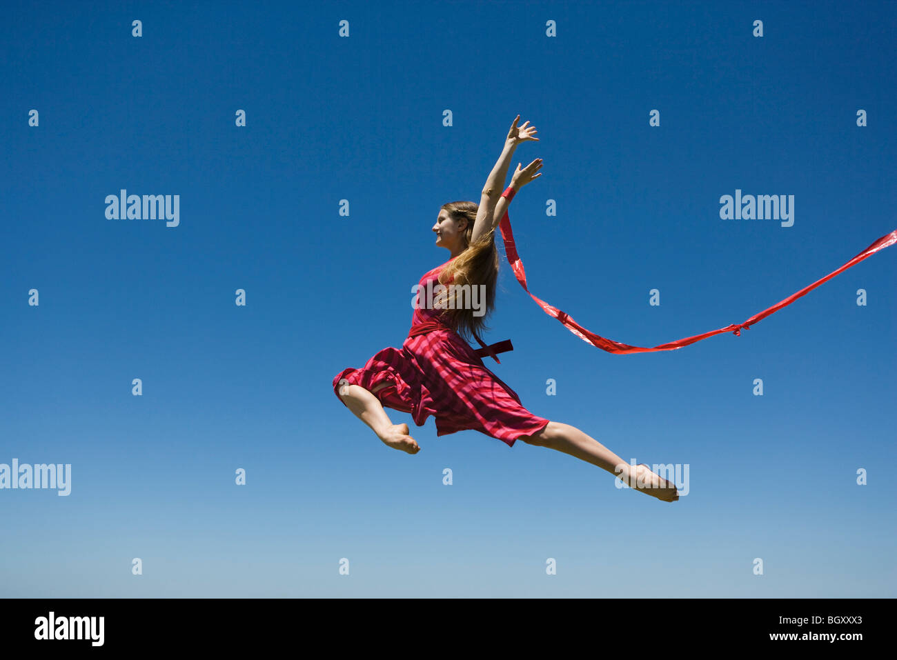 Young woman leaping, midair Stock Photo