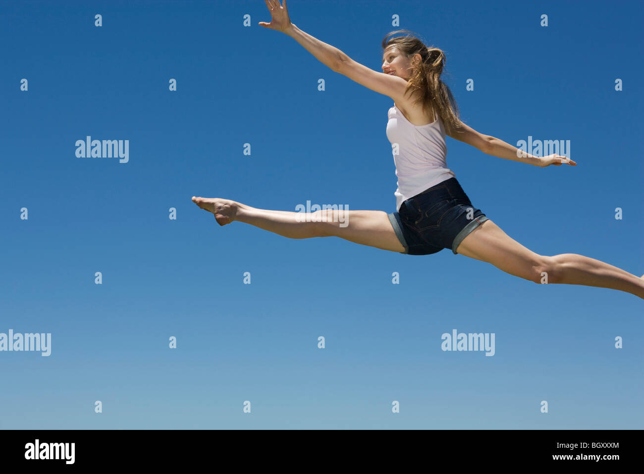Young woman leaping, midair Stock Photo