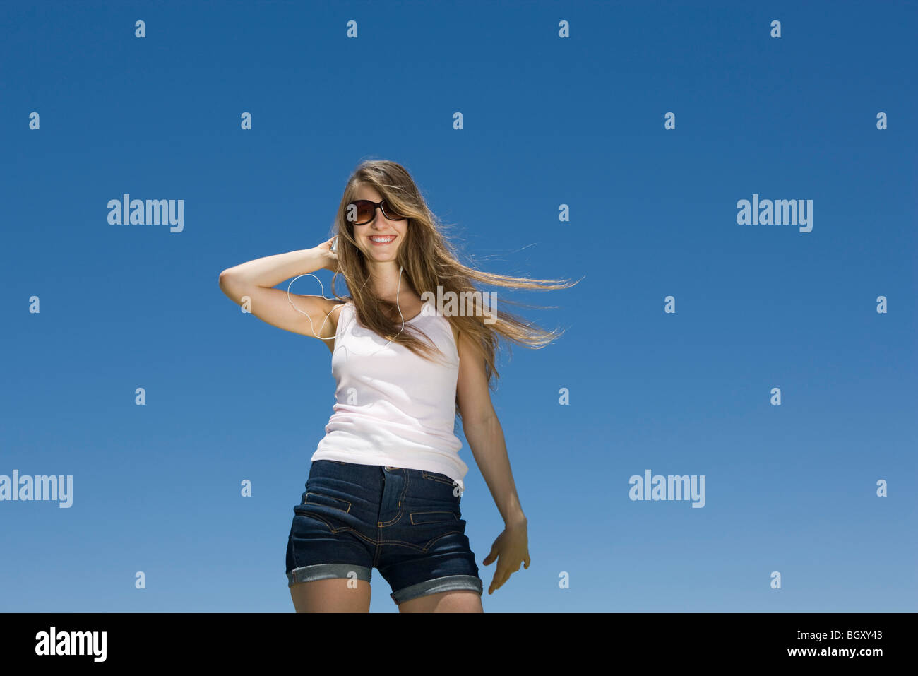 Fashionable young woman in summer apparel with hand in hair Stock Photo