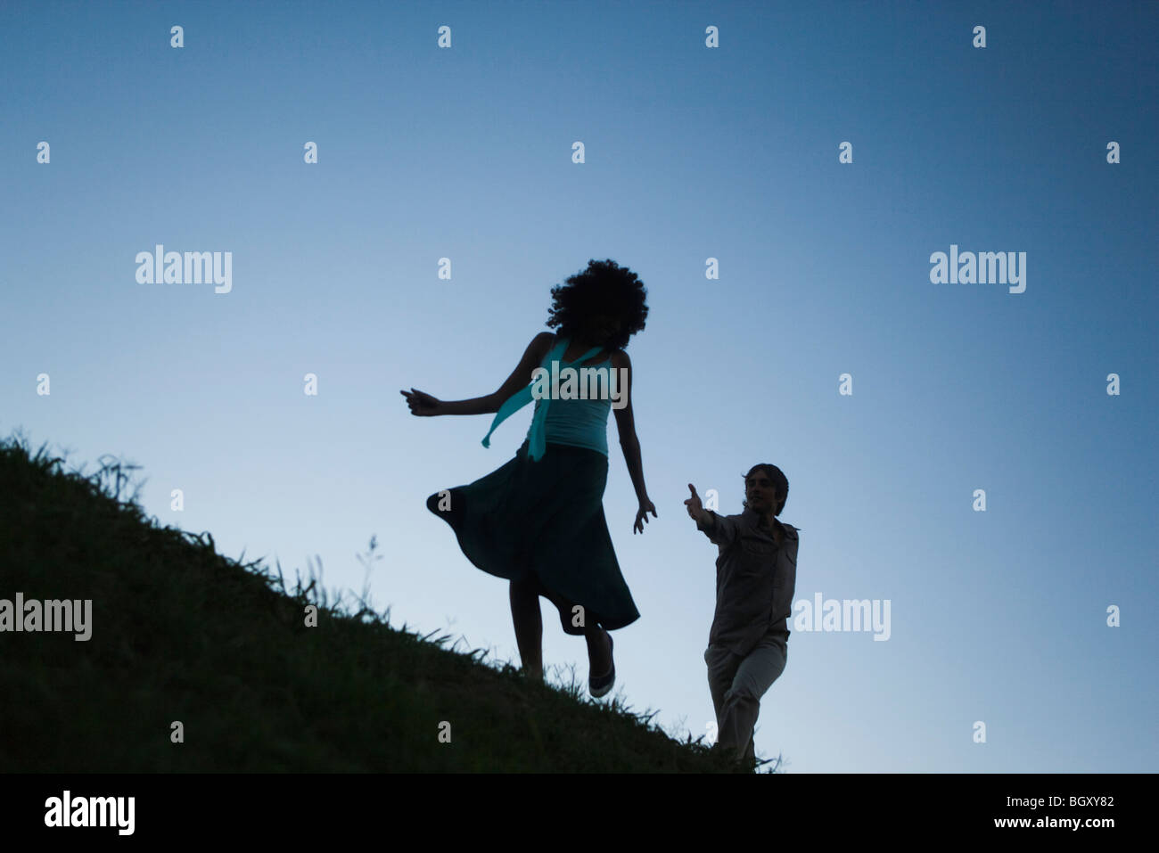 Young woman playfully running away from man in pursuit Stock Photo