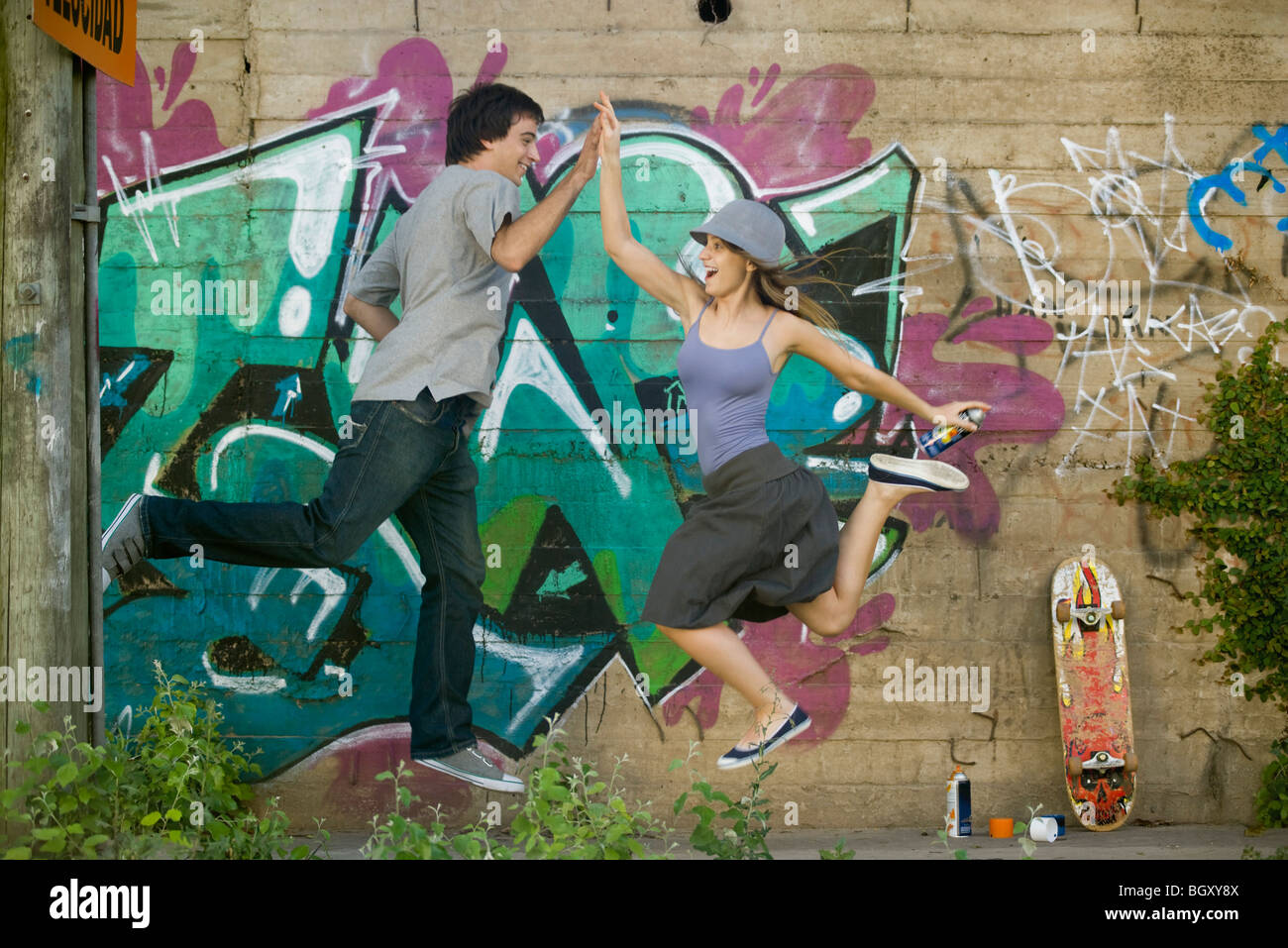 Young couple jumping for high-five Stock Photo