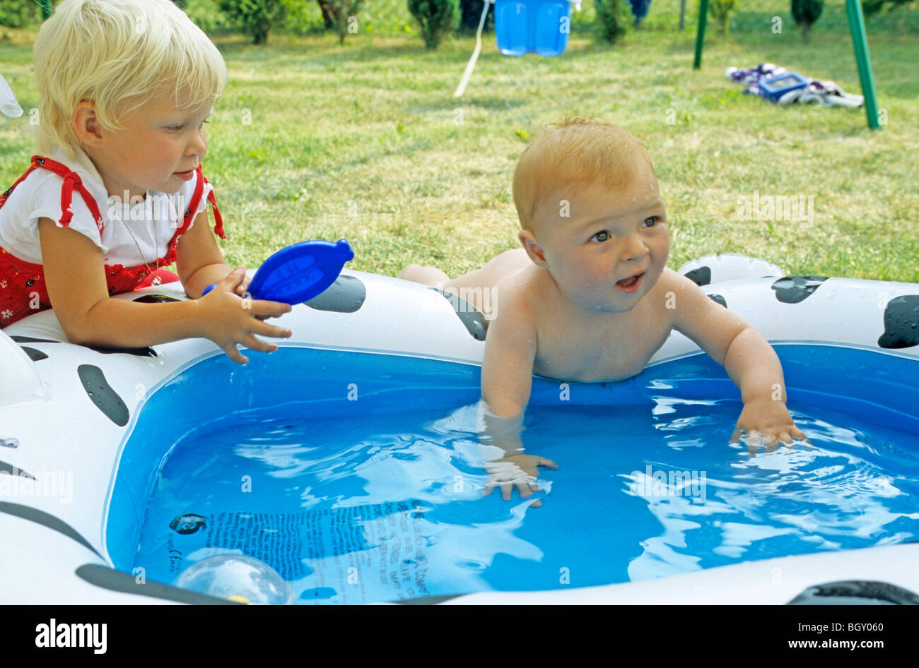 baby boy crawling into a paddling pool Stock Photo Alamy