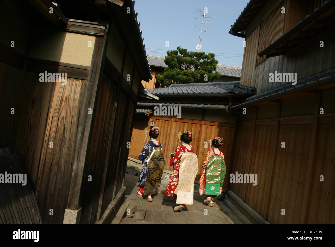 Three girls dressed as 'maiko/geisha' girls walk down Ishibe-Koji Street, in the Gion district of the city famous for geisha. Stock Photo