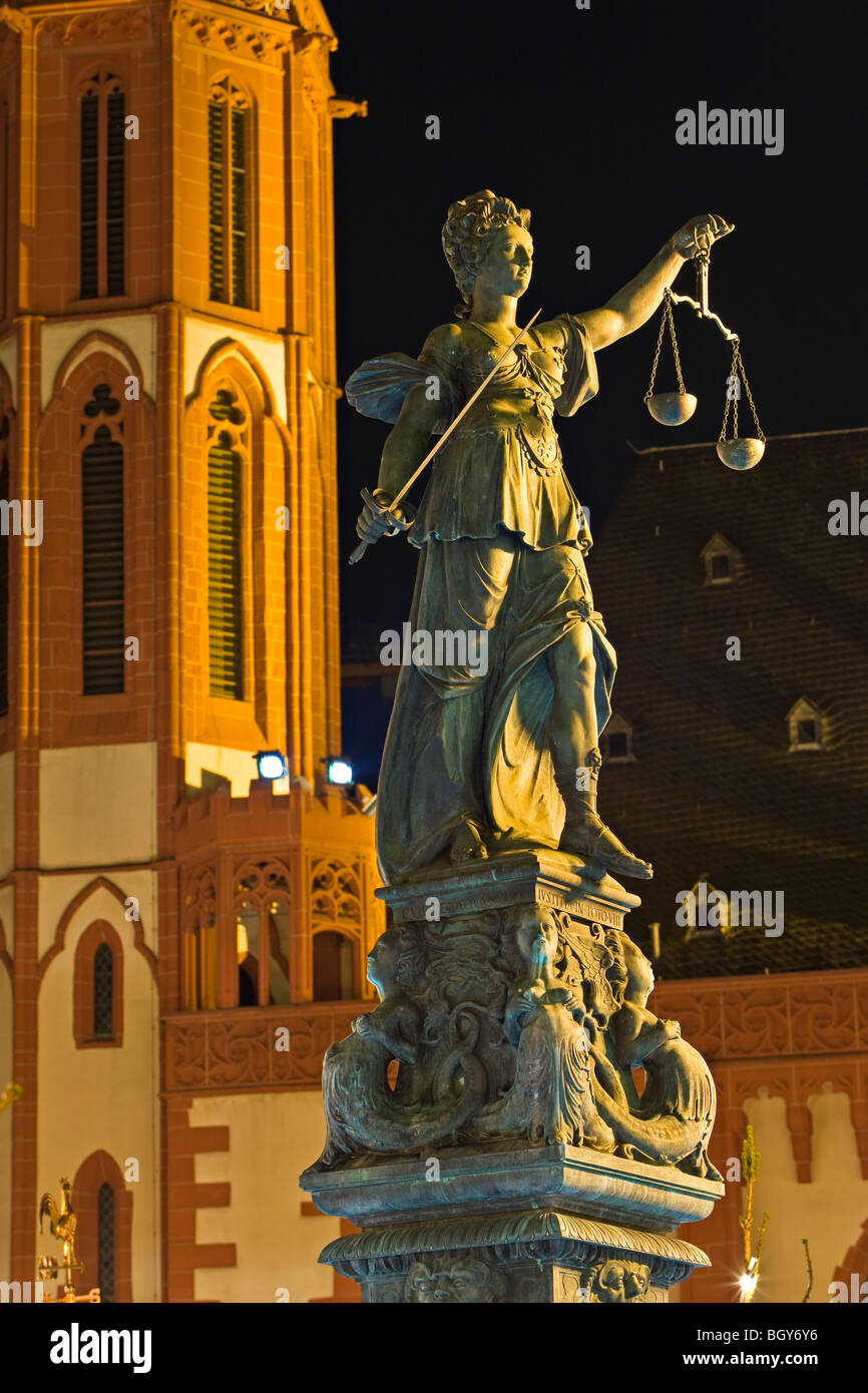 Justitia Statue (Statue of Justice) with Nikolaikirche (St Nicolas Church) in the background in the Römerberg (City Hall Square) Stock Photo
