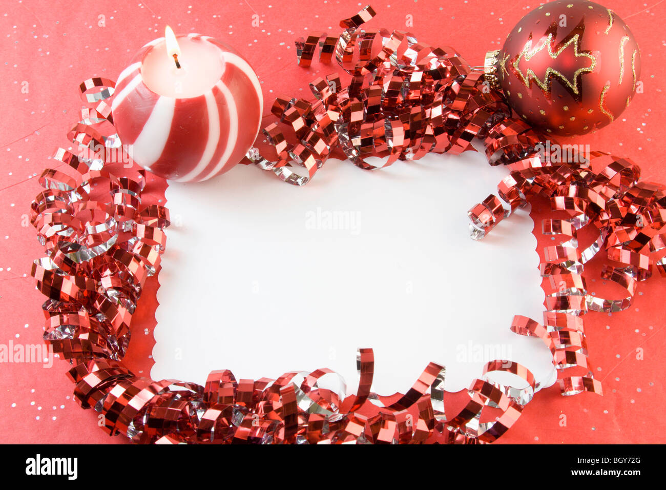 blank Christmas card with metallic red ribbon, candle, bauble and copyspace Stock Photo