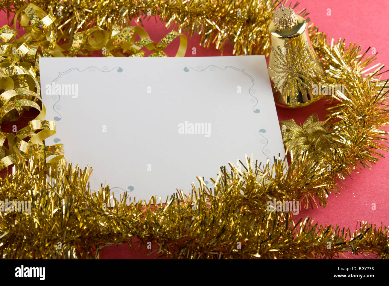 blank christmas card with gold garland, metallic bow, and copy space Stock Photo