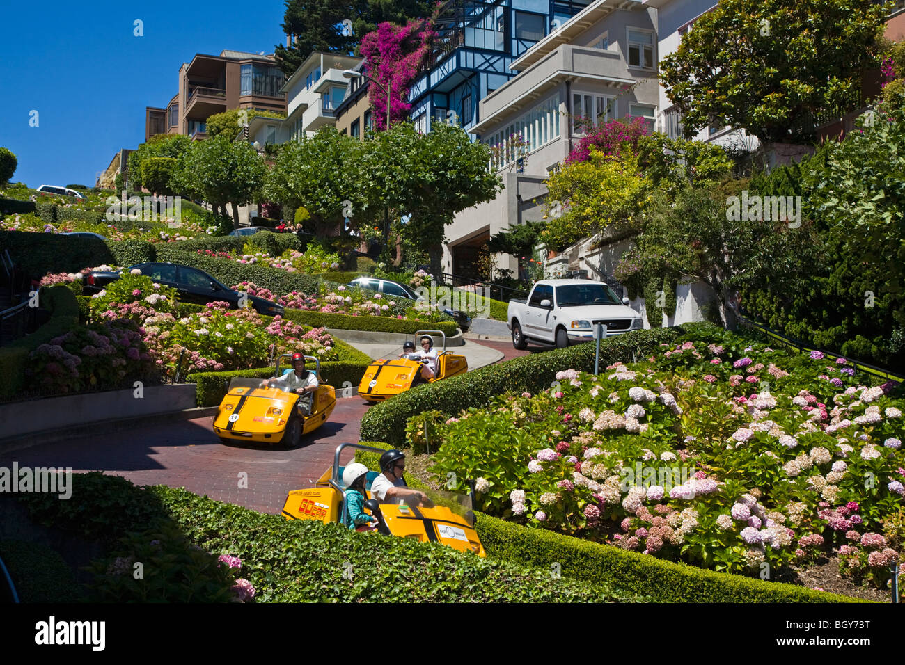 Tourists rent GO CARS and enjoy the twists and turns of LOMBARD STREET - SAN FRANCISCO, CALIFORNIA Stock Photo