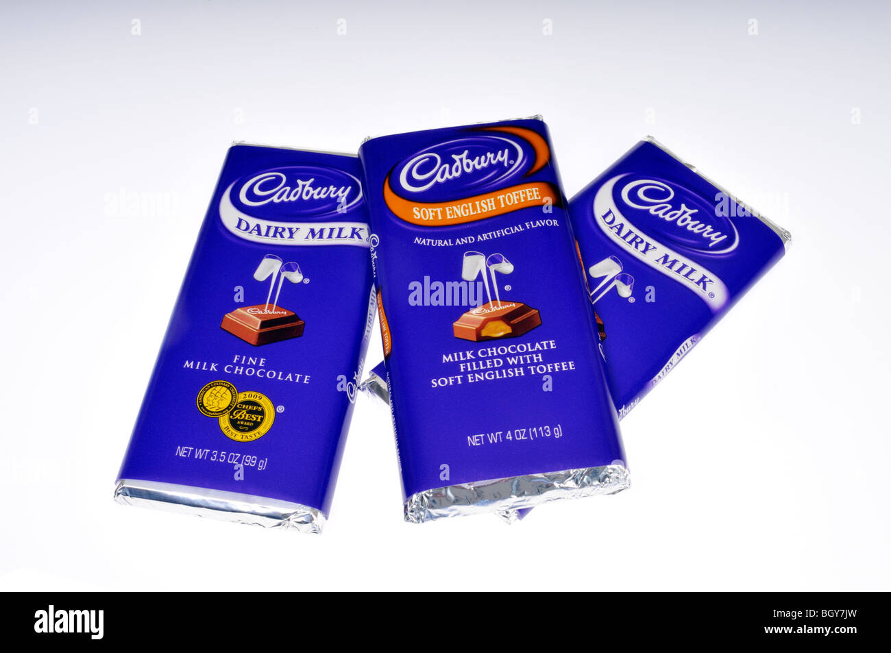3 Cadbury chocolate candy bars in wrappers on white background. Stock Photo