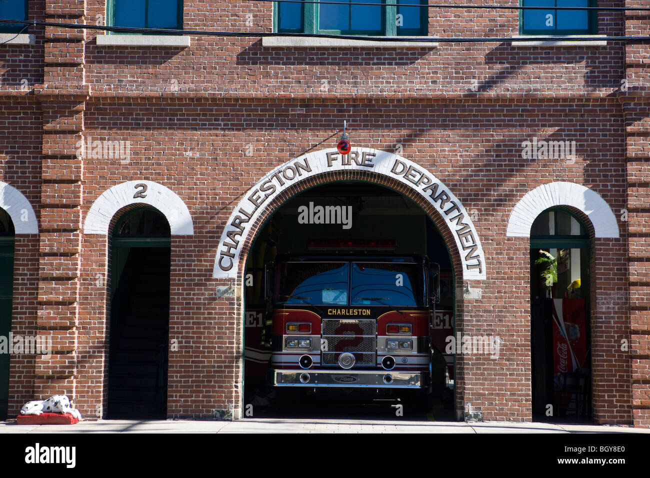 A Dalmatian dog sits out side of the Charleston Fire Department garage for engine 2 on Meeting Street, Charleston Stock Photo