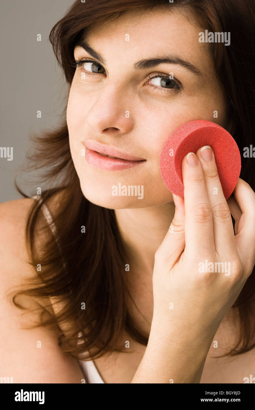 Young woman using cosmetic sponge Stock Photo Alamy