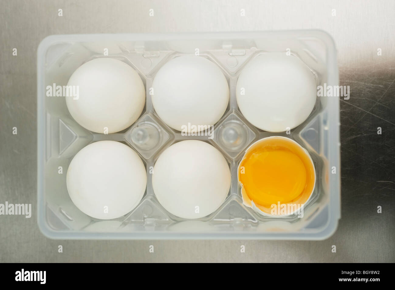 Eggs in egg carton, one cracked open Stock Photo Alamy