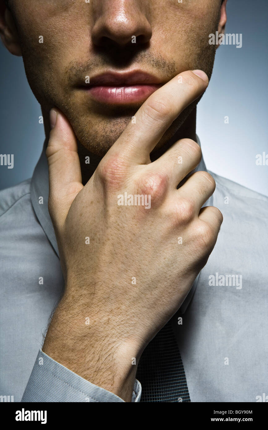 Businessman with hand under chin, portrait Stock Photo Alamy