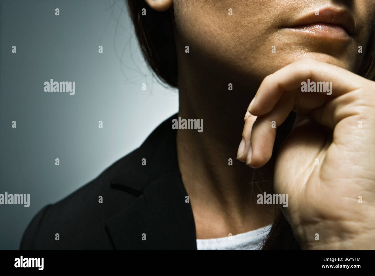Woman with hand under chin, cropped Stock Photo Alamy