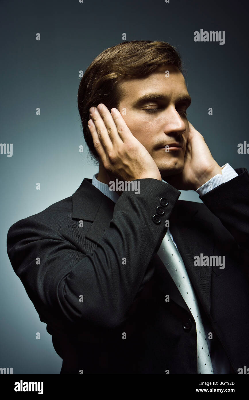Businessman with hands covering ears and eyes closed Stock Photo Alamy